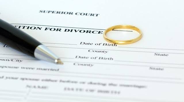 A divorce petition form is shown with a gold wedding ring resting on it
