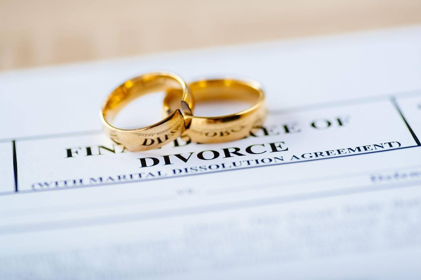 Wedding rings on a divorce paper representing the conclusion of a marital relationship