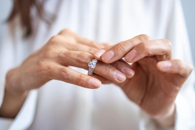 A woman gracefully puts on her engagement ring symbolizing love and commitment