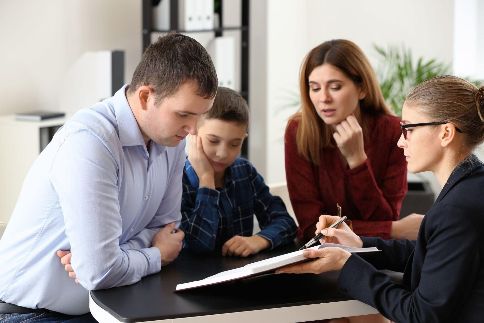 A man and woman are seated at a table with a child enjoying a family moment and discussing their day