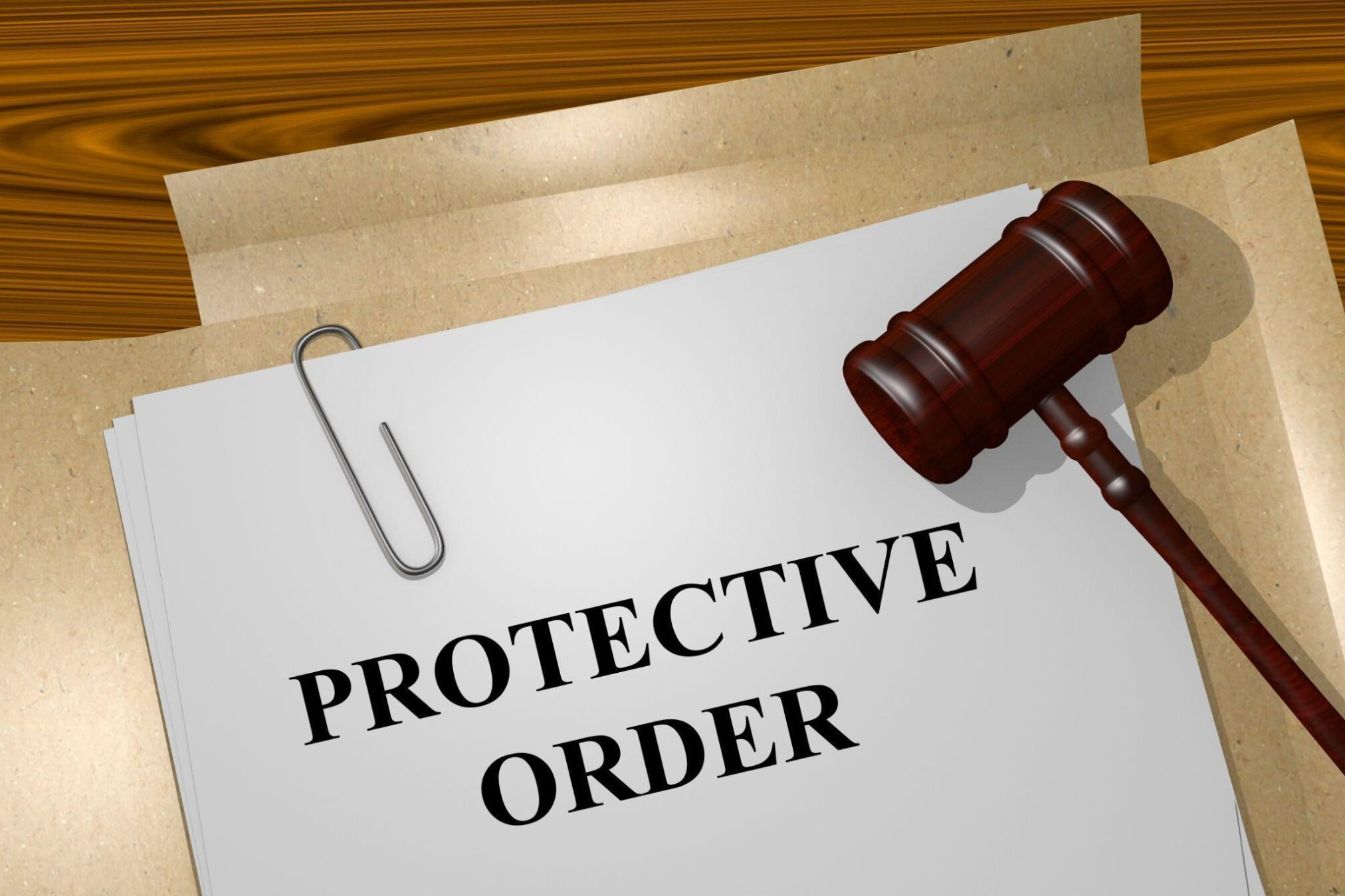 Document labeled Protective Order on a desk with a brown gavel and paperclip